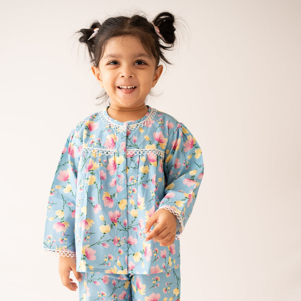 Child wearing a floral pajama set on a plain background