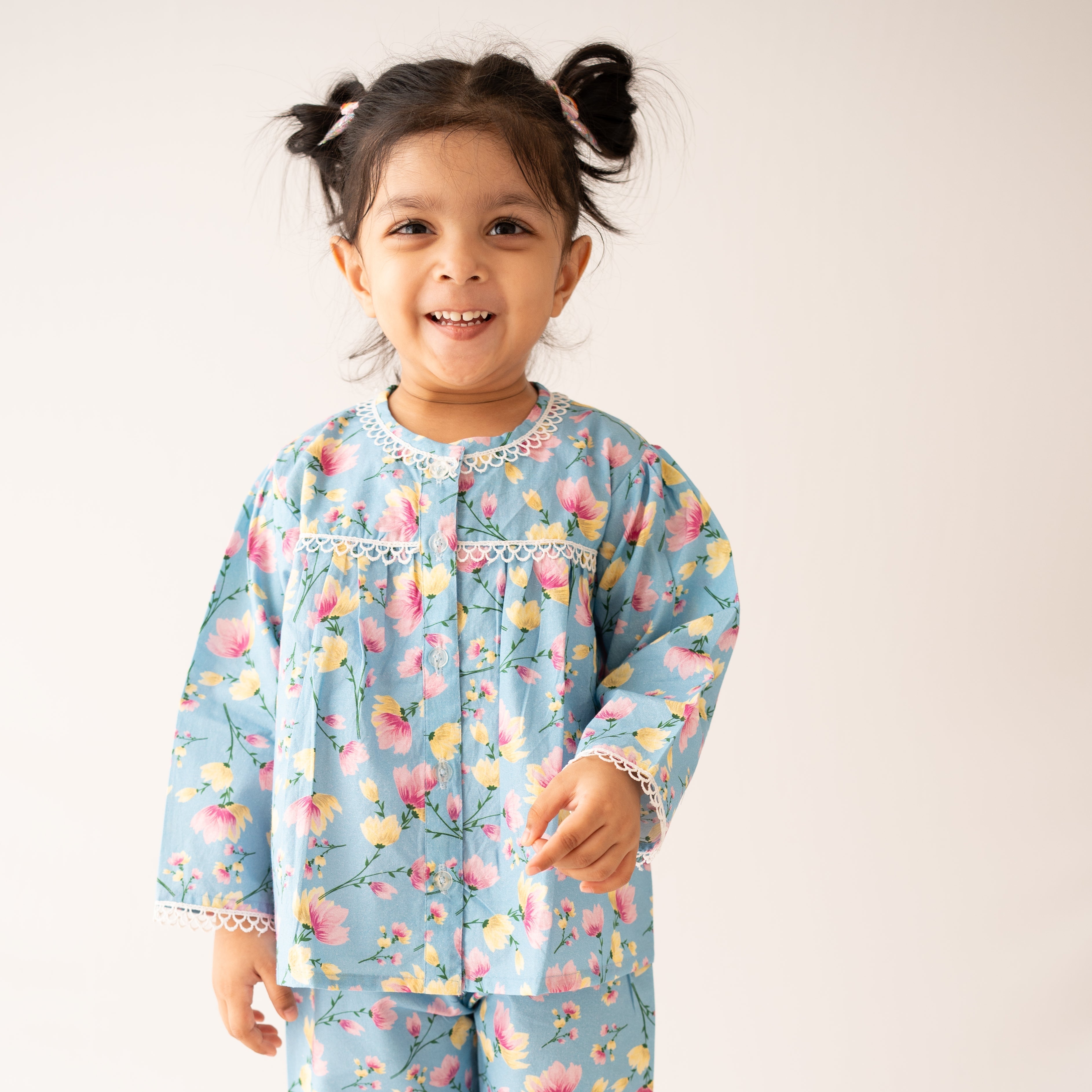 Child wearing a floral pajama set on a plain background