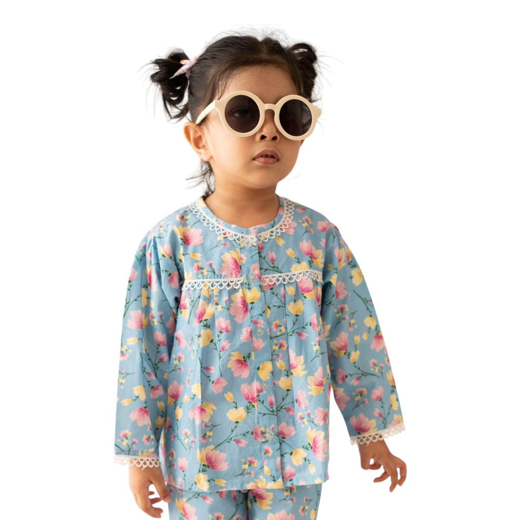Child wearing a colorful pajama set with floral pattern on a white background